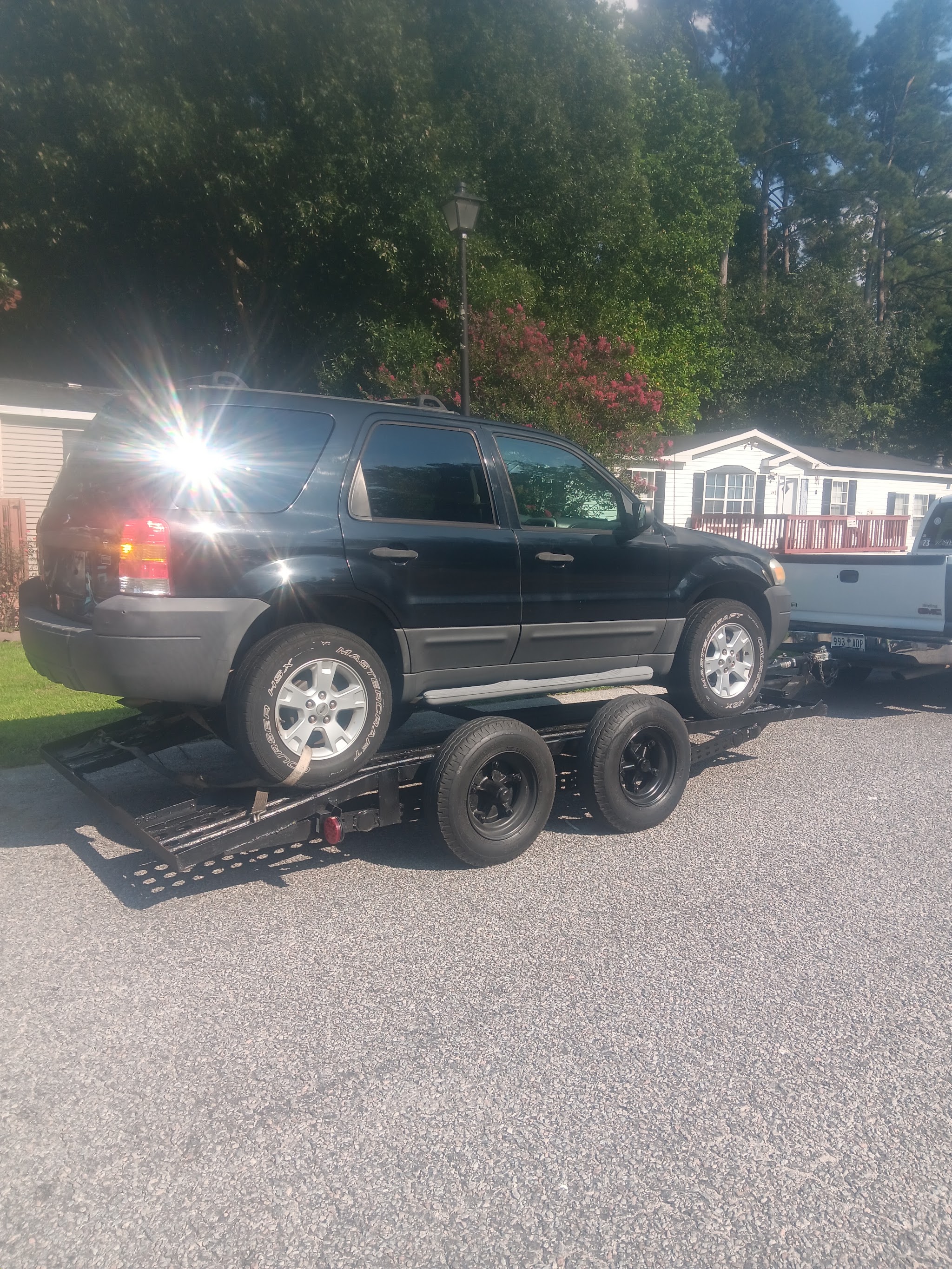 An SUV loaded on a trailer in a driveway